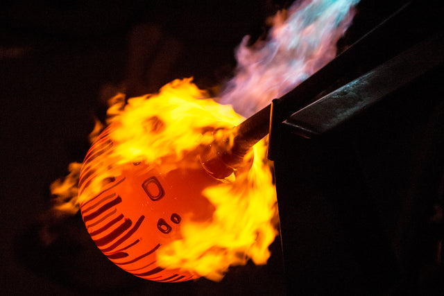 Torching a piece of hot glass during a glassblowing demonstration at Bavin Glassworks